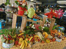 Théâtralisation du rayon fruits et légumes, corbeilles de fruits et sculptures 