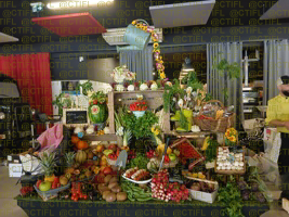 Théâtralisation du rayon fruits et légumes, corbeilles de fruits et sculptures 
